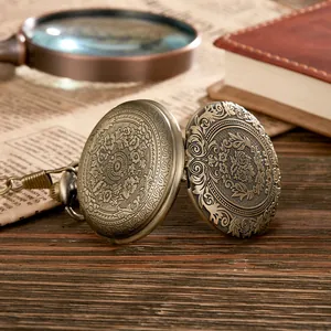 Makrodetail einer antiken Bronze-Taschenuhr mit aufwendiger floraler Hohlraumgravur.