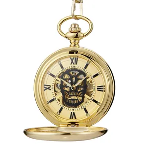 Détail d'une montre à gousset vintage dorée avec cadran tête de mort noir et chiffres romains