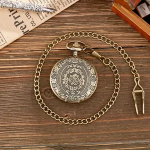Detailansicht einer antiken Vintage-Taschenuhr aus Bronze mit graviertem Blumendeckel.