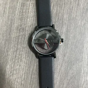Gedetailleerde weergave van het TOMI uniseks horloge met een uniek hol wijzerplaatontwerp.