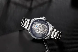 Close-up of a men's silver stainless steel skeleton watch with visible inner gears