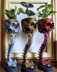 Vue détaillée de trois jardinières crâne avec supports en forme de colonne vertébrale.