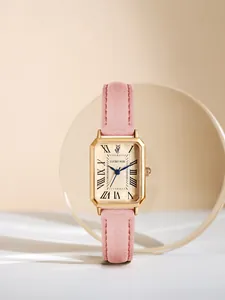 Close-up of a vintage rectangular women's gold-tone watch with pink leather strap