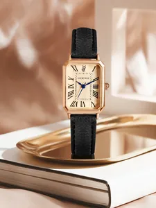 Detail view of a vintage rectangular women's watch with rose gold finish and black strap