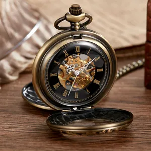 Gros plan d'une montre à gousset vintage en bronze avec mouvement mécanique visible.