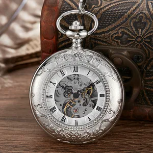 Gros plan d'une montre à gousset squelette argentée avec gravure florale et chiffres romains
