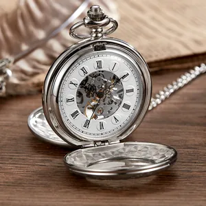 Vue rapprochée d'une montre de poche mécanique argentée vintage avec chiffres romains et cadran squelette