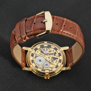 Macro view of skeleton mechanical watch movement with brown leather strap and gold case