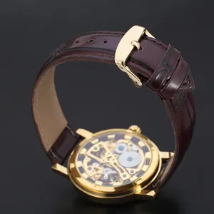 Detailed close-up showing the brown leather strap and golden buckle of a skeleton watch