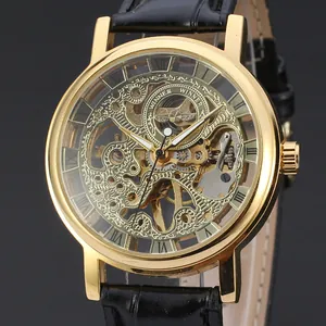 Close-up of gold skeleton mechanical watch with Roman numerals and black leather strap