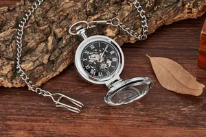 Gros plan d'une montre à gousset mécanique squelette argentée avec couvercle loupe