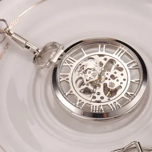 Gros plan d'une montre à gousset squelette argentée avec mouvement mécanique et chiffres romains
