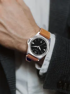 Detailopname van TOMI herenhorloge met zwarte wijzerplaat en bruine lederen band