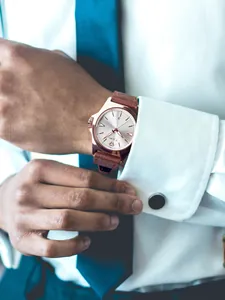 Detailopname van TOMI herenhorloge met bruine leren band en roségouden kast.