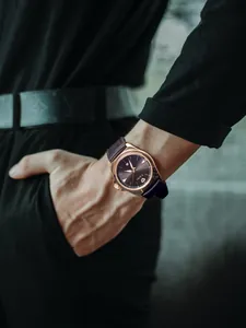 Elegant TOMI herenhorloge quartz met een paarse leren band om de pols detailopname