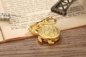 Primer plano de un reloj de bolsillo de tortuga dorada vintage sobre un libro antiguo