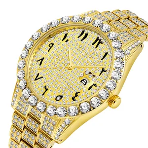 Vue détaillée d'une montre dorée sertie de strass avec chiffres arabes et calendrier