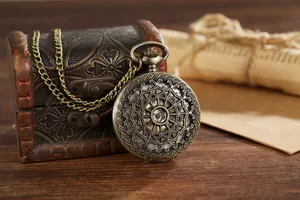 Detailed view of vintage bronze quartz pocket watch featuring an intricate hollow mandala cover