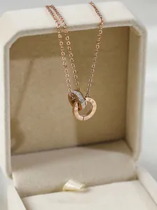 Detailopname van roségouden ketting met dubbele ring en kristallen in geschenkdoos
