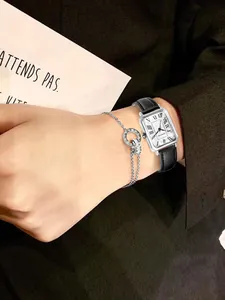 Detailopname van een vintage vierkant horloge met leren band en zilveren armband
