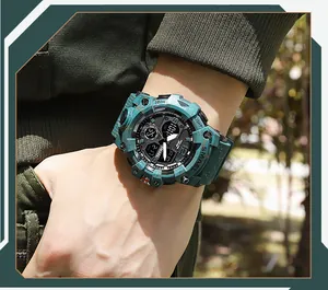 Détail macro d'une montre numérique tactique SMAEL sarcelle portée au poignet dehors.