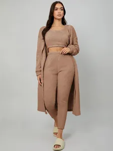 Female model showcasing a three-piece brown plush loungewear set with a long cardigan