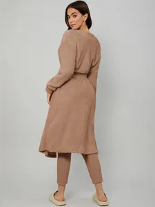 Back view of a cozy tan three-piece plush loungewear set including a long robe. Elegant style.
