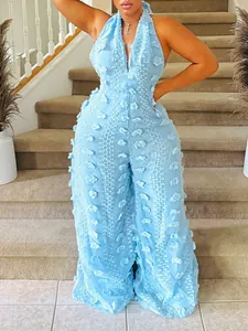 Detailed view of light blue halter neck wide leg jumpsuit with textured tassel fabric.