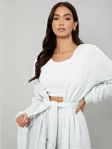Front view of a model wearing a soft white plush 3-piece loungewear set with belt