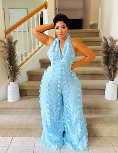 Full-length detail view of a sky blue 3D textured halter neck jumpsuit on a model.