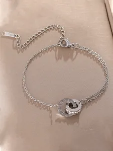 Detailopname van een zilveren roestvrijstalen armband met in elkaar grijpende Romeinse ringen