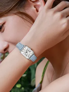 Detailopname van een vintage rechthoekig zilveren horloge met lichtblauwe leren band