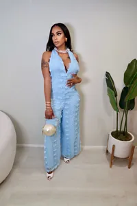 Close-up view of light blue halter V-neck jumpsuit featuring 3D floral textured fabric