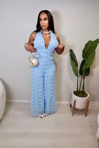 Detailed view of fashionable light blue textured halter neck jumpsuit with deep V-neckline.