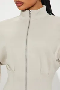 Detail des figurbetonten Langarmkleids mit Stehkragen, Frontreißverschluss und Korsett-Taille