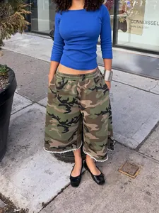 Modèle portant un short de jogging camouflage vintage à jambes larges avec ourlet brut en rue