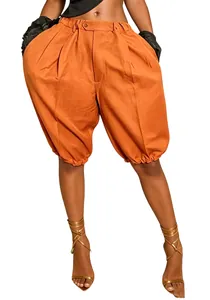 Waist-down view of vibrant orange pleated lantern shorts with unique elastic hem design