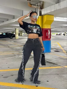 Jeans a zampa alla moda con dettagli a frange in un garage urbano sotterraneo