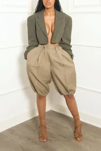 Close-up of stylish khaki lantern shorts paired with a fashionable olive green cropped blazer.