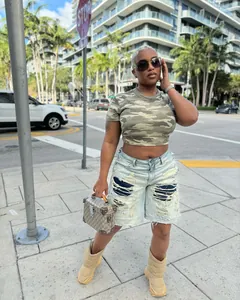 Street style look featuring distressed patchwork denim shorts with urban background