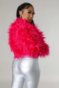 Giacca corta in ecopelliccia fucsia vivace da donna abbinata a pantaloni argento.