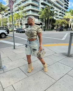 Fashionable women's street style distressed ripped denim shorts in a light blue wash