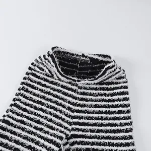 Dettaglio macro dei pantaloni in maglia a righe bianche e nere con trama a vita alta