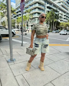 Street style model wearing light blue washed distressed ripped five-point denim shorts
