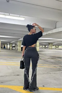 Vista posteriore di jeans a zampa neri vintage con dettagli sfrangiati unici sulle cuciture.