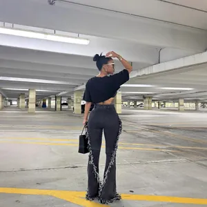 Jeans a zampa retrò neri di tendenza con dettagli di frange laterali e vita alta.