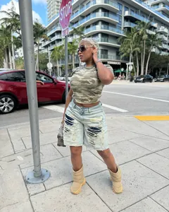 Distressed knee-length denim shorts with patchwork and ripped details in street style