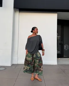 Modell trägt modische Camouflage-Cargo-Hose mit weitem Bein und grauem schulterfreiem Top