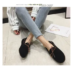 Elegante schwarze Wildleder-Loafer mit brauner Schleife in einer Lifestyle-Umgebung