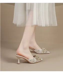 Elegante muiltjes met spitse neus, fonkelende strass-strik en slanke kitten-hakjes.
